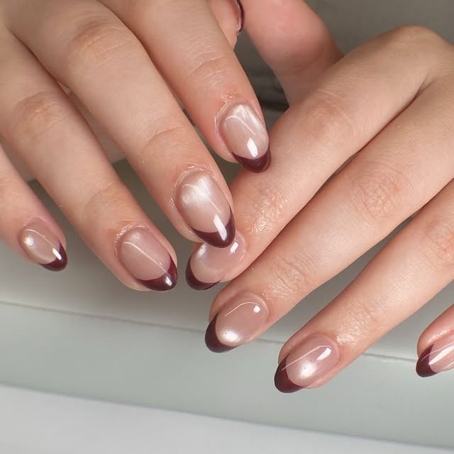 Deep merlot French tips on nude almond nails