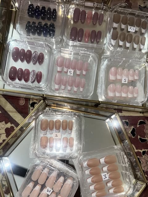 Dozens of finished press-on sets boxed and labelled by size