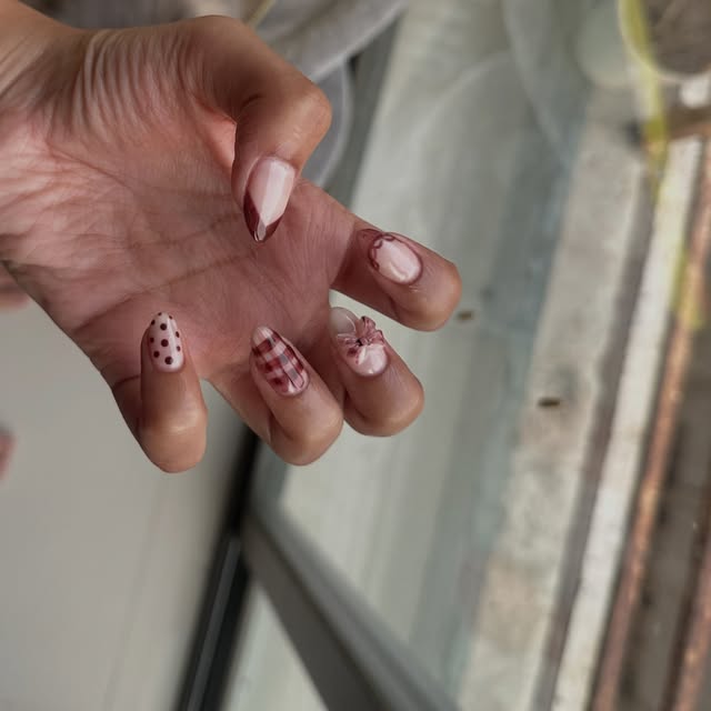 Burgundy gingham and polka-dot nails with a sculpted 3D bow